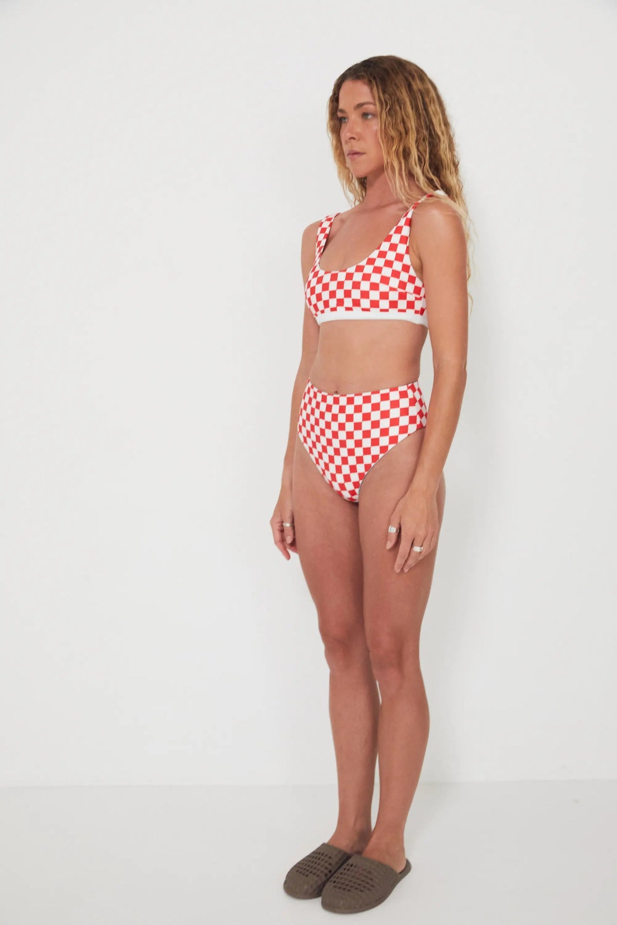 Woman wearing a red and white checkered bikini set on a white background