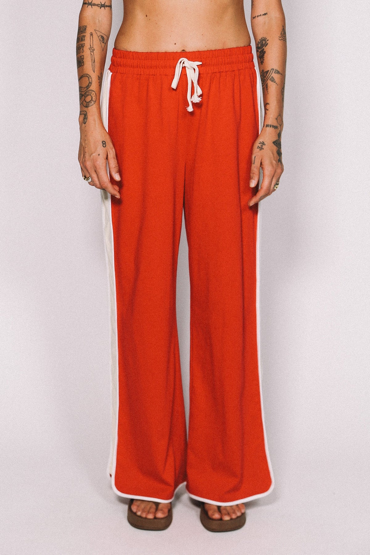Red pants with a white drawstring on a plain background