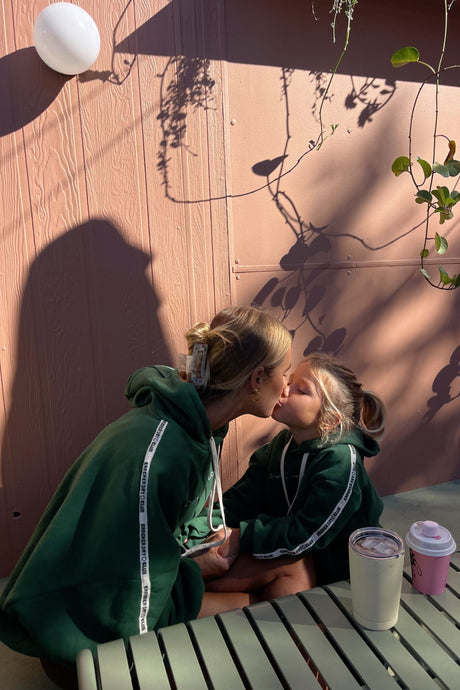mum and daughter hanging out at a coffee shop wearing forest green cloud sweaters by cracker day club