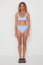 Woman wearing a light blue bikini with red accents on a white background
