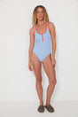 Woman wearing a light blue swimsuit with red accents on a white background