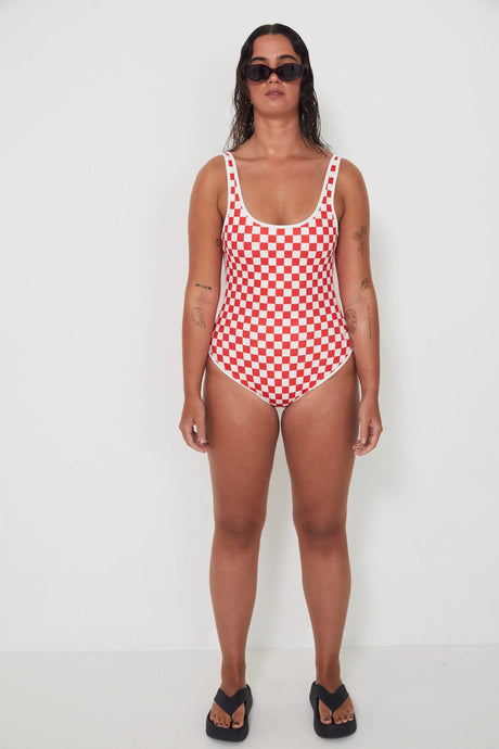 Woman wearing a red and white checkered swimsuit on a white background