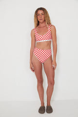Woman wearing a red and white checkered bikini set on a white background