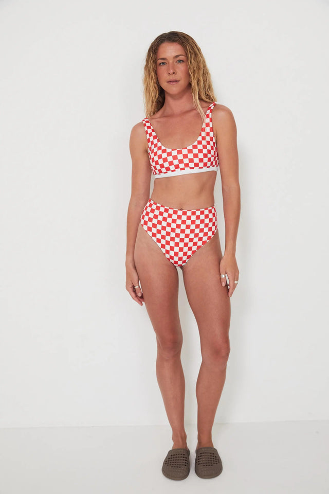 Woman wearing a red and white checkered bikini set on a white background
