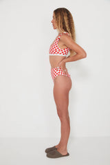 Woman wearing a red and white checkered bikini on a white background