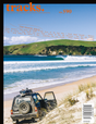 Cover of 'tracks.' magazine issue 590, featuring a travel edition with an image of a beach and a vehicle on sand dunes.