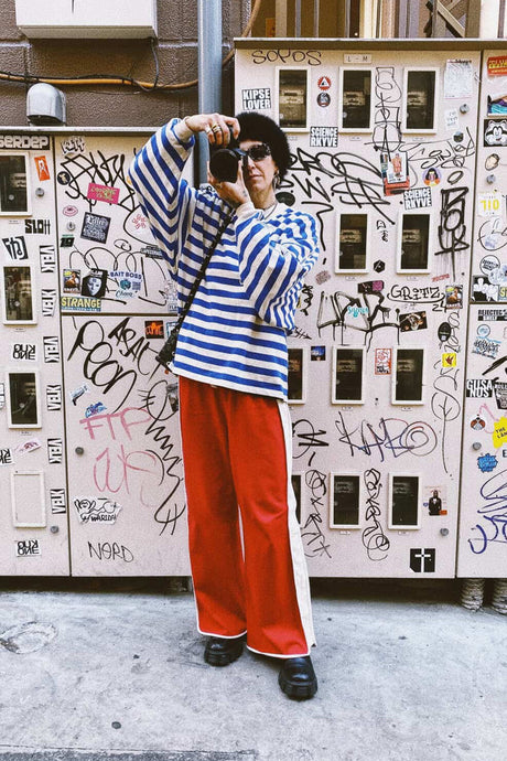 Person taking a selfie in front of a graffiti-covered wall