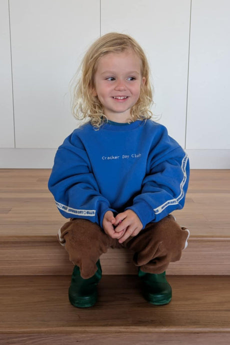 little boy wearing a blue oversized sweater by cracker day club