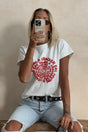 white baby tee styled with ripped denim jeans on a blonde woman