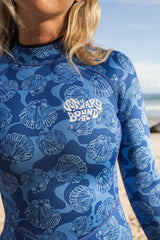 Person wearing a blue shell 2mm spring suit with the logo Sunward Bound