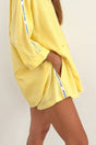 Yellow outfit with white and blue stripes on a plain background